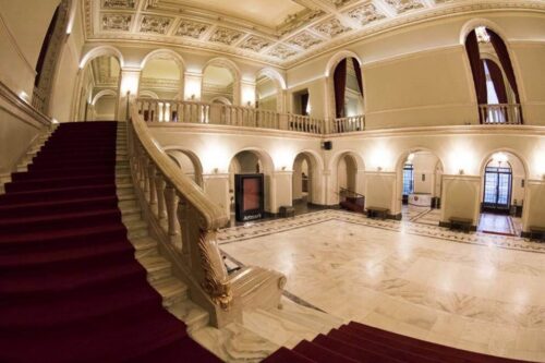 Holul de intrare al Operei Naționale București, cu scara monumentală de marmură și covor roșu